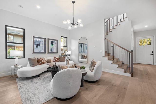 a living room with patio furniture and a chandelier