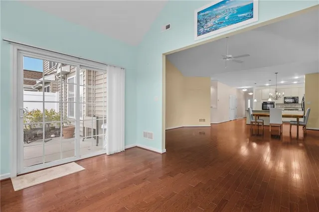 a view of empty room with wooden floor and floor to ceiling window