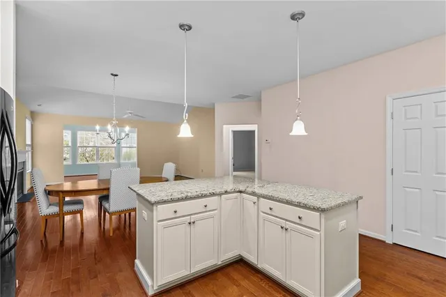 a kitchen with a granite countertop sink window and chairs