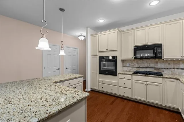 a kitchen with stainless steel appliances granite countertop a stove a sink and a microwave