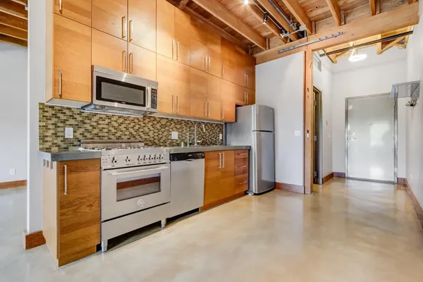 a kitchen with stainless steel appliances granite countertop a stove and a refrigerator
