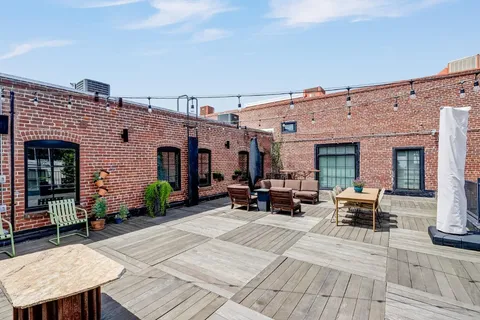 a view of a patio with table and chairs with wooden floor and fence