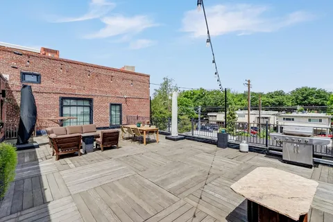 a view of a patio with couches and chairs with wooden floor