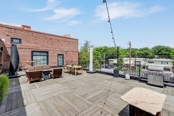 a view of a patio with couches and chairs with wooden floor