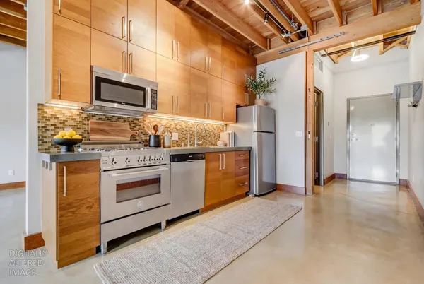 a kitchen with stainless steel appliances granite countertop a stove and a refrigerator