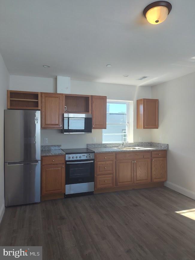 4230 6th Street Southeast, Unit 1 Washington, DC 20032 - Photo 10 of 25 a kitchen with stainless steel appliances granite countertop a stove a sink and a refrigerator