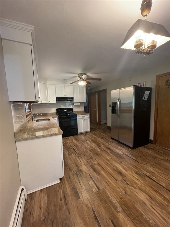 7 Albert Street Billerica, MA 01821 - Photo 10 of 33 a kitchen with stainless steel appliances granite countertop a refrigerator a sink dishwasher a stove and white countertops with wooden floor