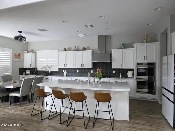 a kitchen with stainless steel appliances granite countertop a stove a sink a refrigerator and white cabinets