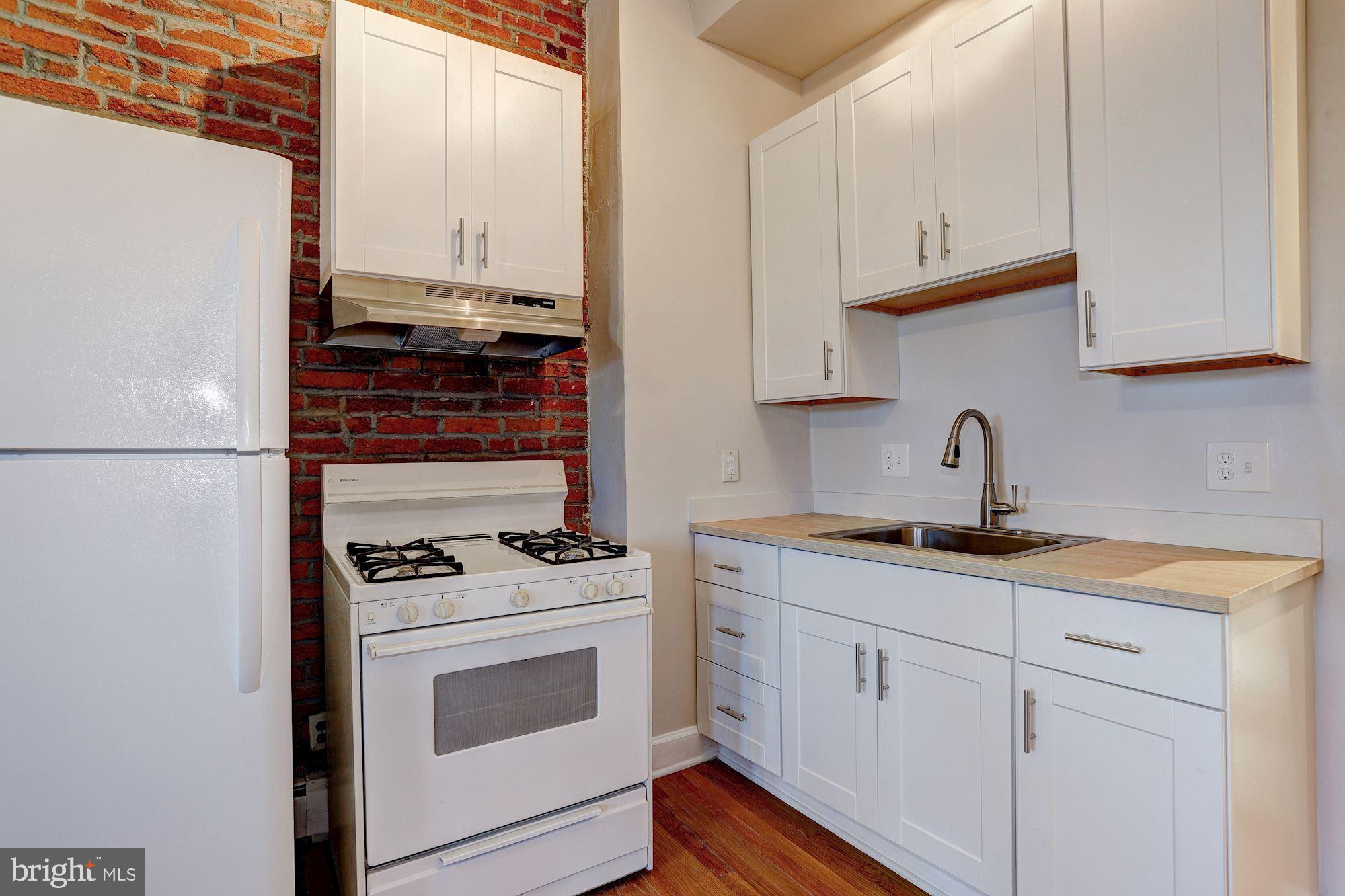 1837 Bolton Street, Unit 2 Baltimore, MD 21217 - Photo 7 of 12 a kitchen with granite countertop white cabinets and white appliances