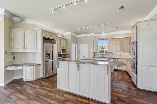 a kitchen with white cabinets and stainless steel appliances
