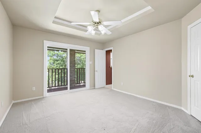 an empty room with windows and ceiling fan
