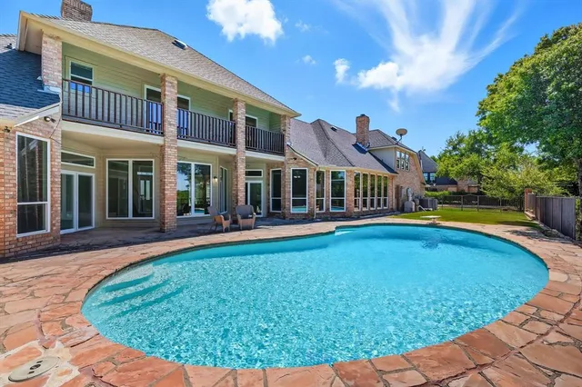 a view of a patio with wooden floor next to a yard
