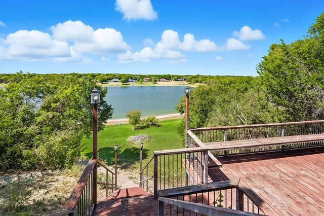 an aerial view of residential houses with outdoor space and lake view