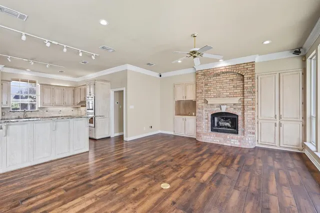 a view of empty room with wooden floor and fireplace