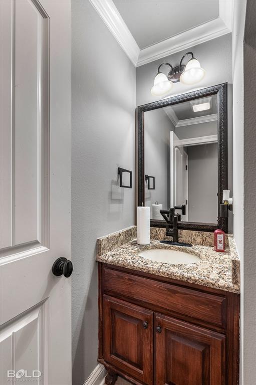 2220 Forest Hills Boulevard Haughton, LA 71037 - Photo 25 of 40 Bathroom vanity featuring a wood cabinet with dual doors, a granite countertop with an undermount sink, and a matte black faucet