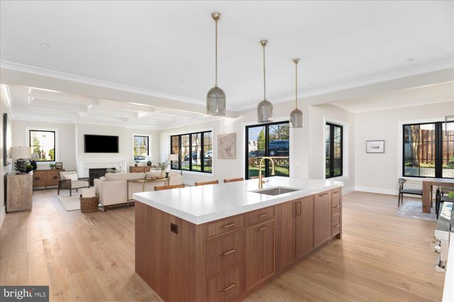 a view of a dining room and livingroom with furniture wooden floor a chandelier