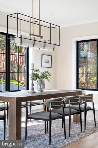 a kitchen with stainless steel appliances granite countertop a sink a stove a dining table and chairs with wooden floor