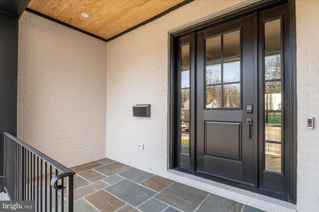 a view of a hallway with wooden floor and a living room