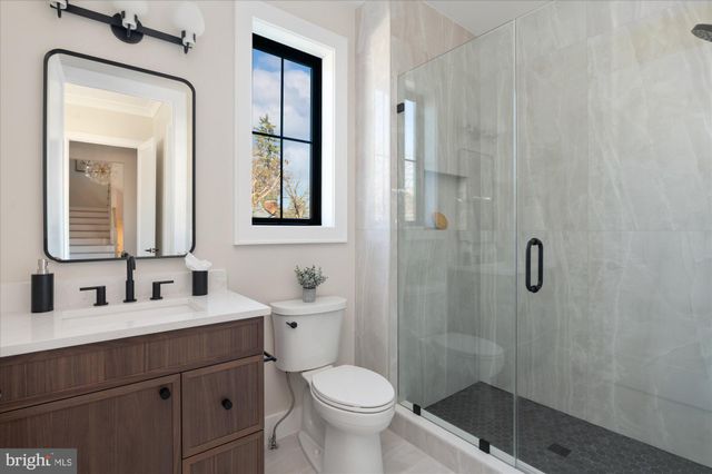 a spacious bedroom with a bed couch and windows