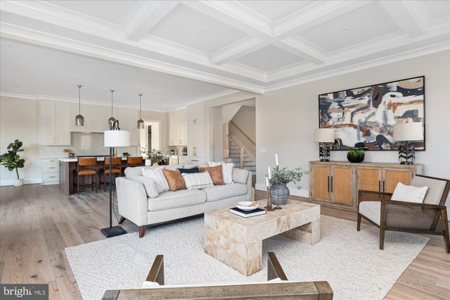 a kitchen with stainless steel appliances a stove a sink a dining table and chairs with wooden floor