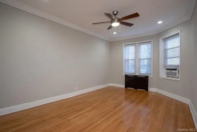 an empty room with window and ceiling fan