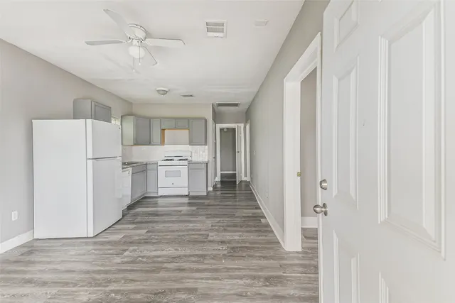 a view of a kitchen with refrigerator and white cabinets