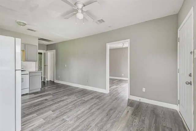a view of a kitchen with wooden floor and a refrigerator