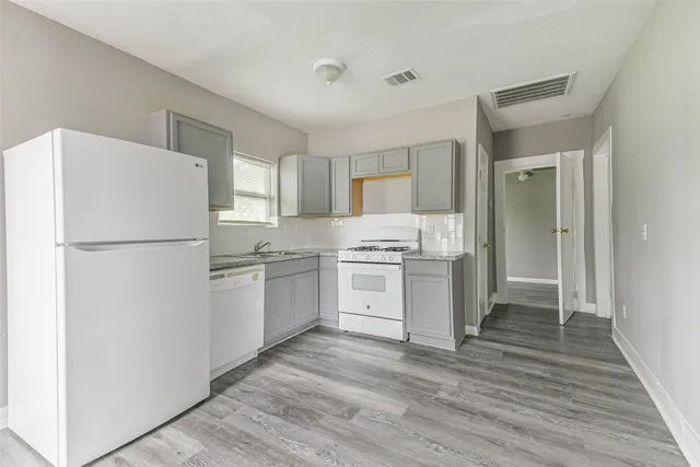 a kitchen with a refrigerator and a stove top oven