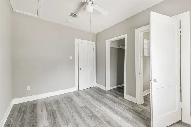 a view of a room with wooden floor closet and a ceiling fan