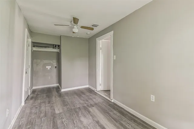 a view of a hallway with wooden floor and a chandelier