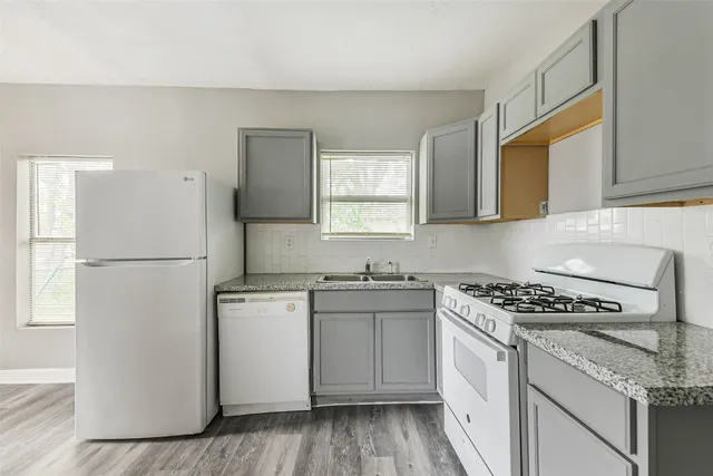 a kitchen with granite countertop cabinets stainless steel appliances and a wooden floor