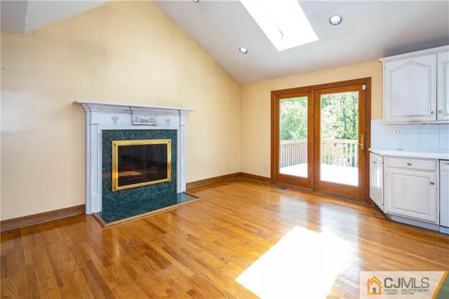 a view of empty room with wooden floor and fireplace
