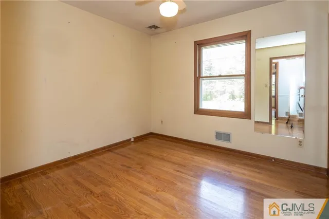 a kitchen with stainless steel appliances a stove a sink and white cabinets with wooden floor