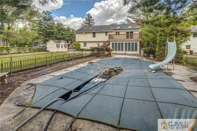 an aerial view of residential house with outdoor space and trees all around