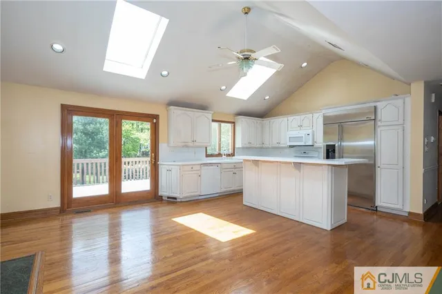 a large kitchen with lot of counter space and a wooden floor