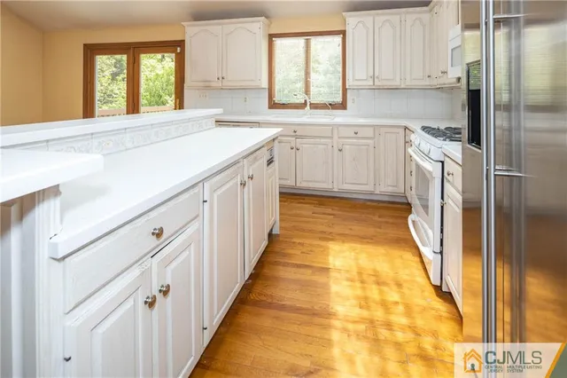 a bathroom with a granite countertop sink and dishwasher with a large window
