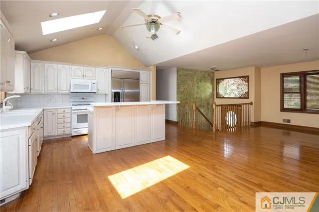 a living room with stainless steel appliances kitchen island granite countertop wooden floors and view living room