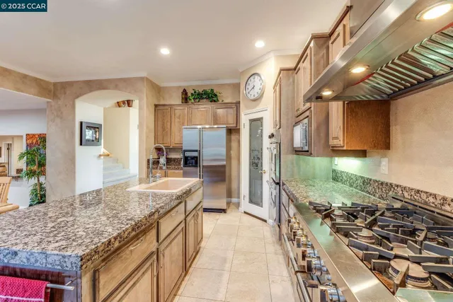 a kitchen with kitchen island granite countertop a stove and a sink