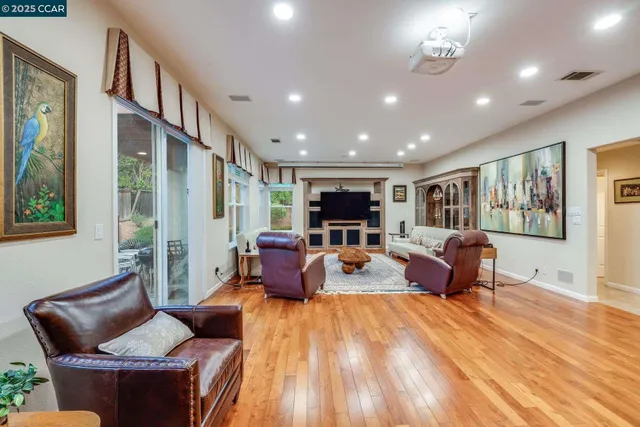 a living room with furniture kitchen view and a large window