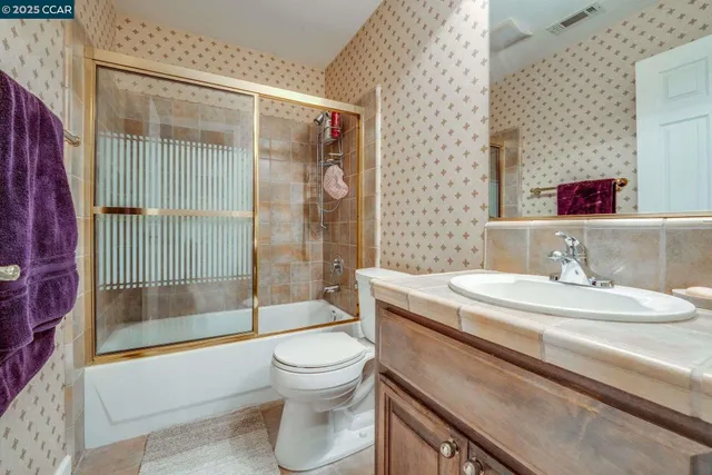 a bathroom with a granite countertop sink a toilet and bathtub