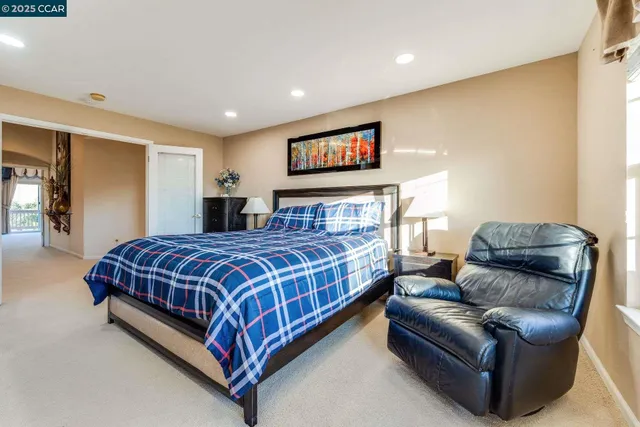 a spacious bedroom with a bed and large windows