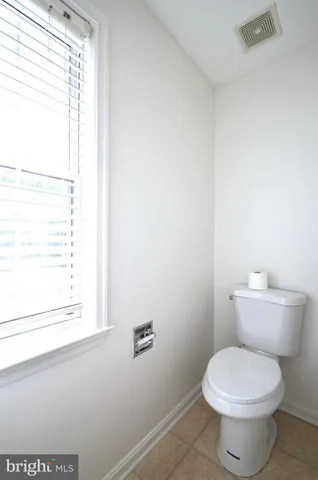 a white toilet sitting next to a window