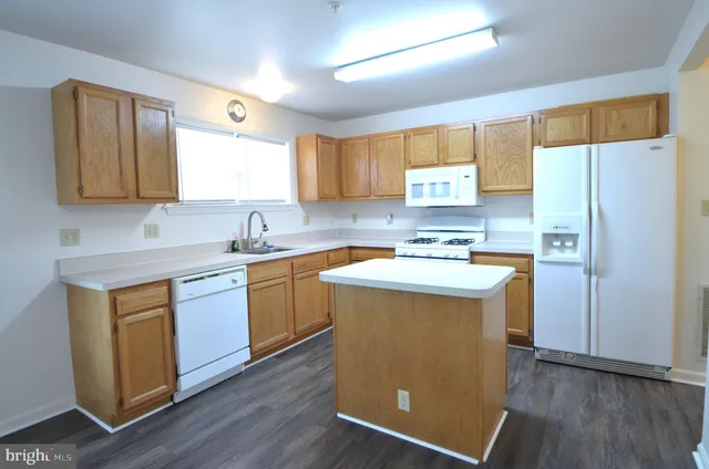 a kitchen with a refrigerator sink and cabinets