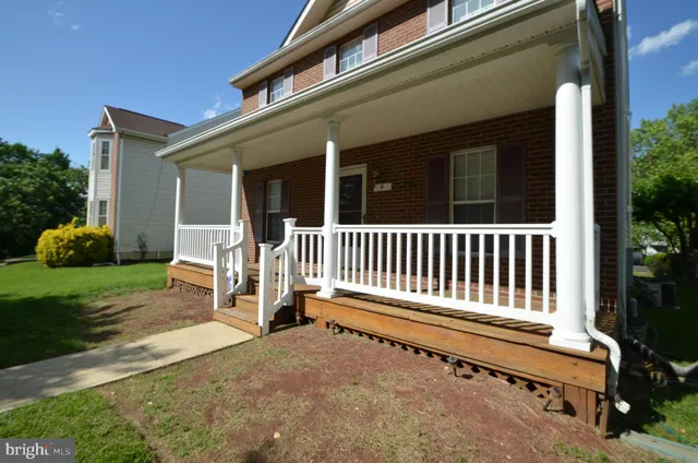 a backyard of a house with table and chairs and a large tree