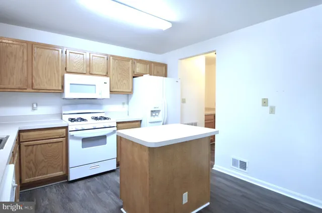 a kitchen with a sink a stove and white cabinets