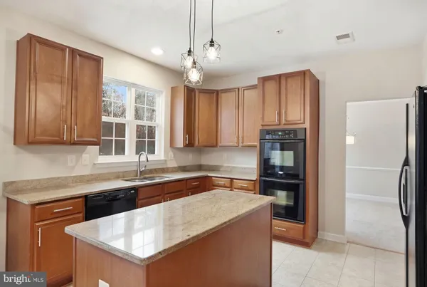 a kitchen with a sink a counter top space cabinets and stainless steel appliances