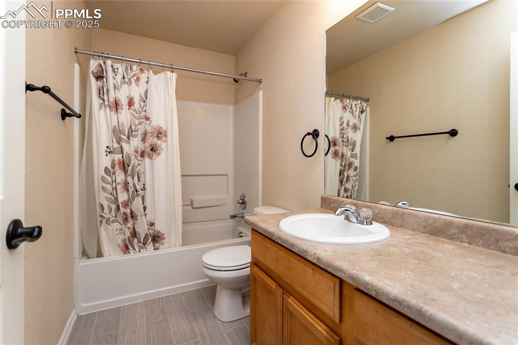 6806 Red Cardinal Loop Colorado Springs, CO 80908 - Photo 25 of 32 a bathroom with a granite countertop sink toilet and shower