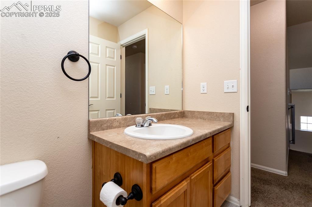 6806 Red Cardinal Loop Colorado Springs, CO 80908 - Photo 26 of 32 a bathroom with a granite countertop sink and a mirror