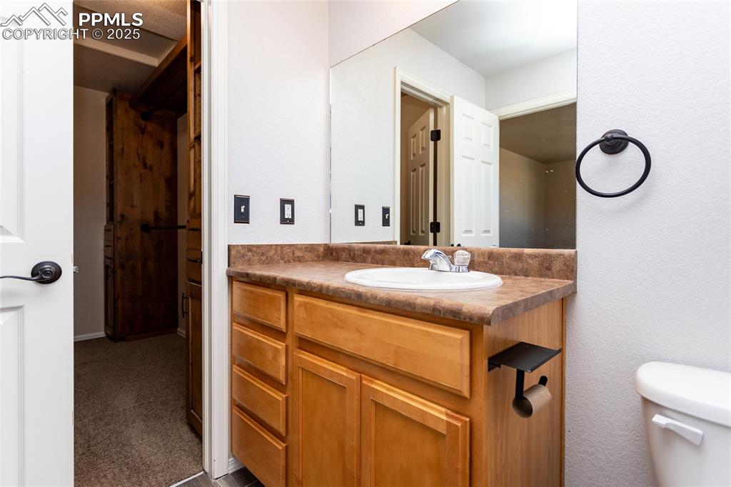 6806 Red Cardinal Loop Colorado Springs, CO 80908 - Photo 28 of 32 a bathroom with a granite countertop sink and a mirror