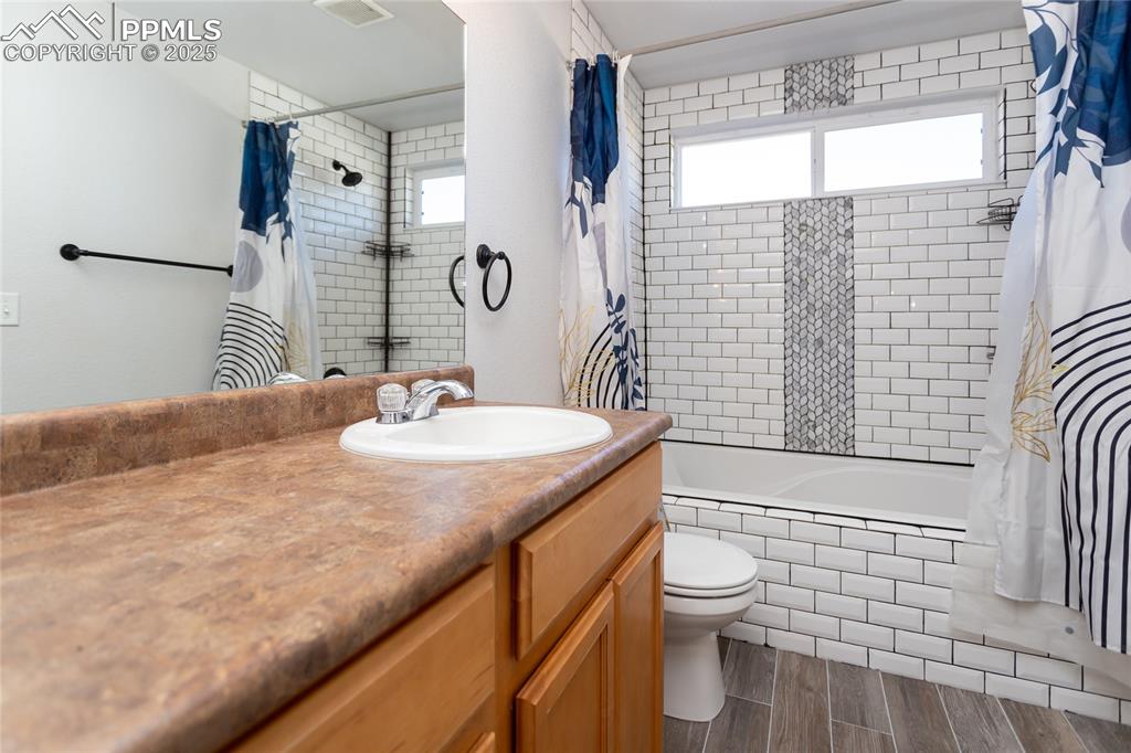 6806 Red Cardinal Loop Colorado Springs, CO 80908 - Photo 30 of 32 a bathroom with a granite countertop sink toilet and shower
